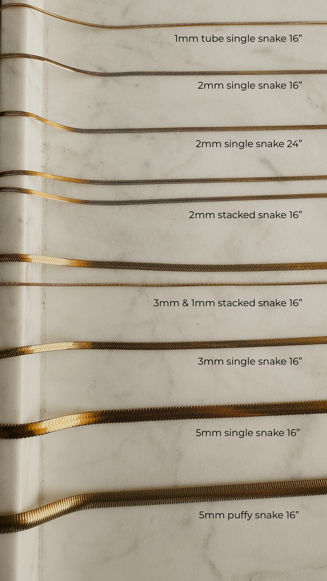 Gold snake chain shown in all different sizes and styles laid out on marble