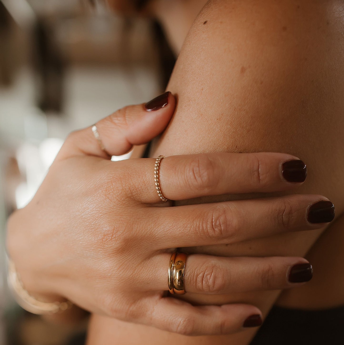 Dark nail polish with a stretchy beaded ring and two stainless steel stacked rings